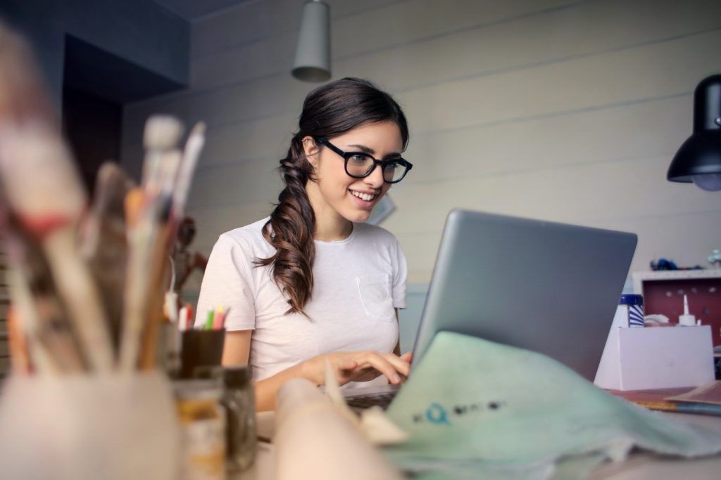 foto di donna che indossa occhiali utilizzando un computer portatile