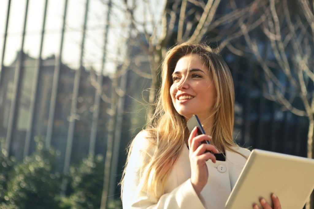 immagine della donna in possesso di un telefono cellulare e sorridente